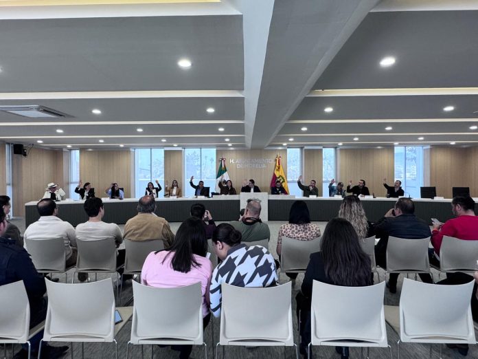 Morelia ejercerá 5 mil 022 mdp en 2026; 9% más que en 2025 Con 12 votos a favor, el Cabildo de Morelia aprobó el Presupuesto de Ingresos y Egresos para el ejercicio fiscal 2026, que contempla una asignación total de 5 mil 022 millones 531 mil 774 pesos, lo que representa un incremento del 9% respecto al presupuesto de 2025. La votación se realizó por mayoría, con la ausencia de las regidoras Verónica Zamudio, de Morena, y Edna Martínez Nambo, del PRI. De acuerdo con el dictamen técnico aprobado este 17 de diciembre, el monto global se compone de 1 mil 108 millones de pesos provenientes de organismos paramunicipales, y 3 mil 913 millones derivados de la recaudación de impuestos municipales. Entre las dependencias con mayor asignación presupuestal destacan: - Secretaría de Administración, con 846 millones 689 mil pesos. - Secretaría de Servicios Públicos, con 653 millones 305 mil pesos. - Secretaría de Seguridad y Protección Ciudadana, con 466 millones 406 mil pesos. - Obras, subsidios y apoyos por asignar, con 377 millones 624 mil pesos. - Secretaría de Obras Públicas Municipales, con 208 millones de pesos. - Secretaría de Bien Común y Política Social, con 164 millones 780 mil pesos. Por otro lado, las instituciones con menor presupuesto serán: - Agencia de la Ciudad Inteligente y Transformación Digital, con 18 millones de pesos. - Consejo Ciudadano del Municipio de Morelia, con 2 millones de pesos. - Instituto Municipal de Planeaci